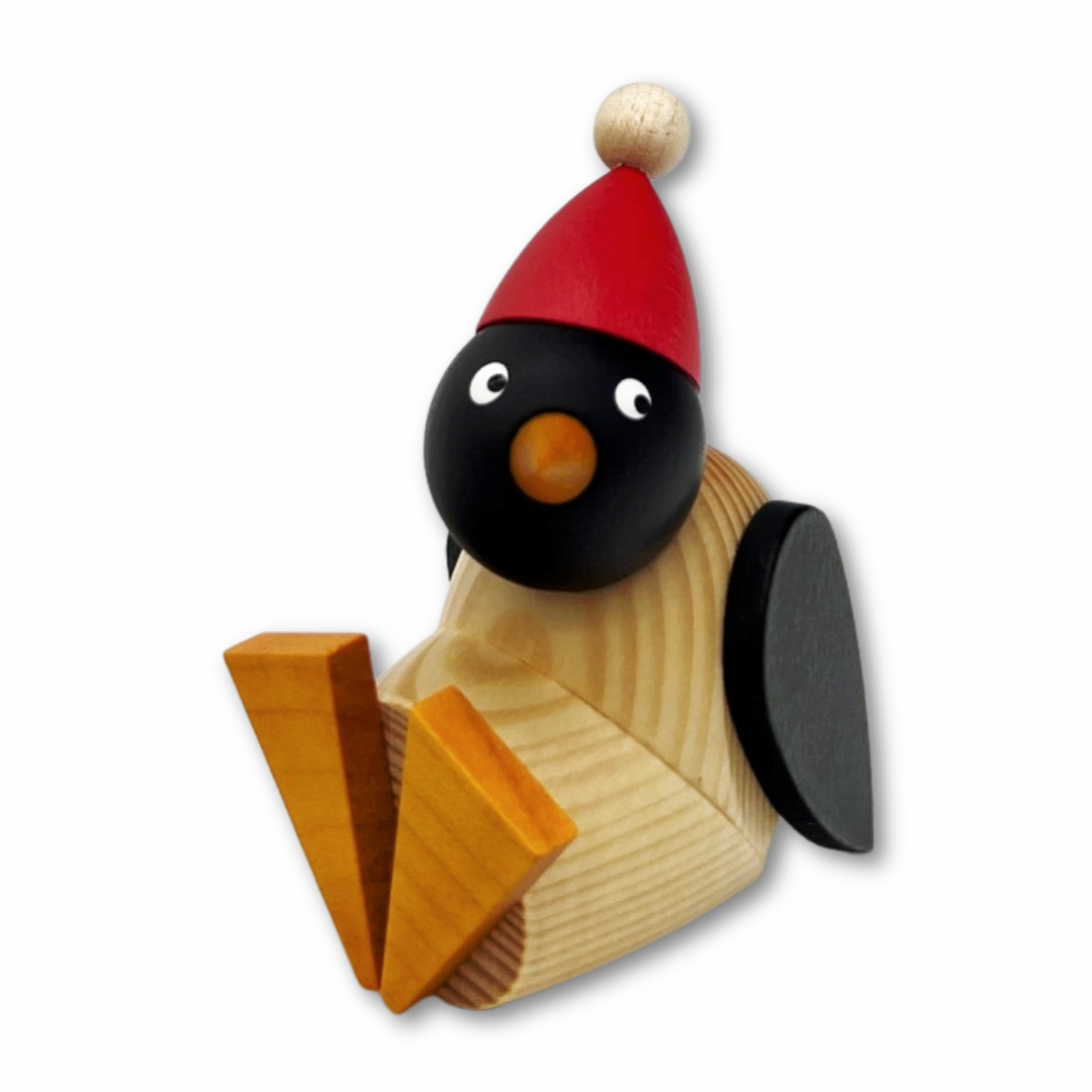 Pinguinkind mit roter Mütze, sitzend