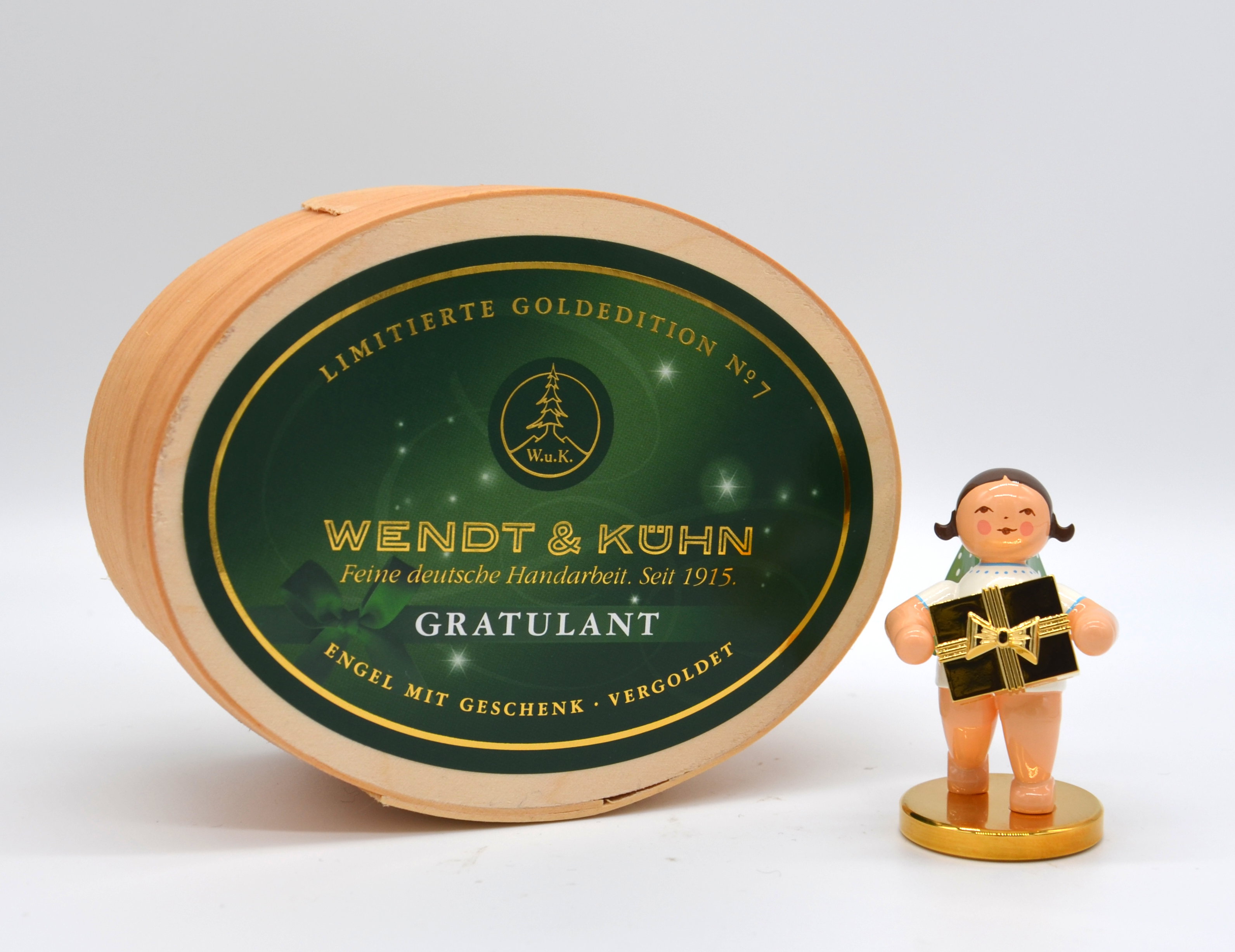 No. 7, Gratulant, Engel mit Geschenk auf Metallsockel · vergoldet, in Spanschachtel. Limitierte Goldedition (22.222 Stück)